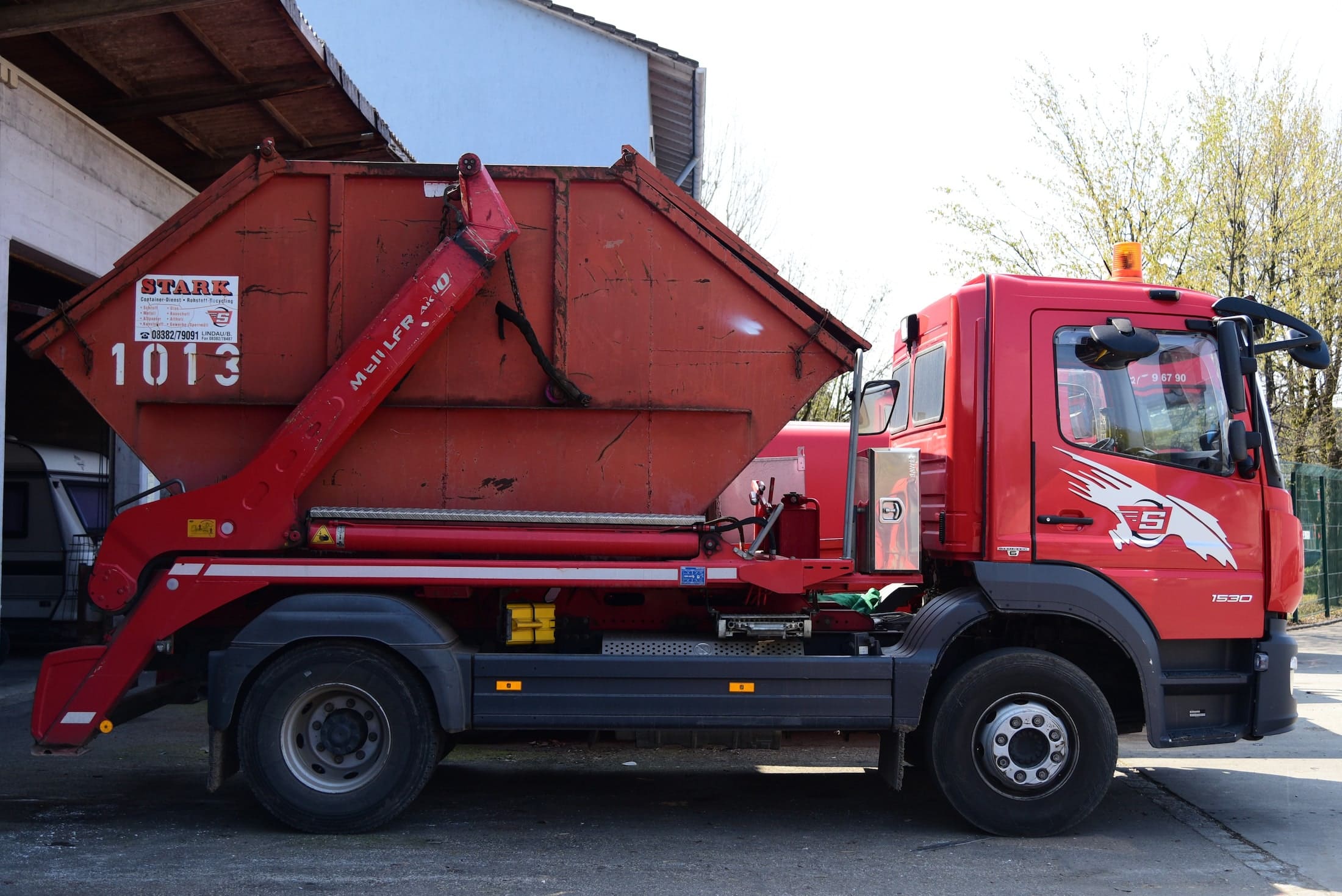 Containerdienst in Wangen im Allgäu - Roter LKW mit Container